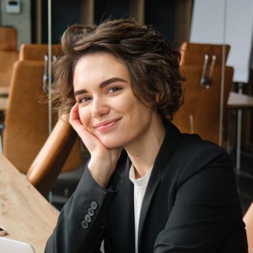 Une femme d'affaires assise à une table avec un ordinateur portable.