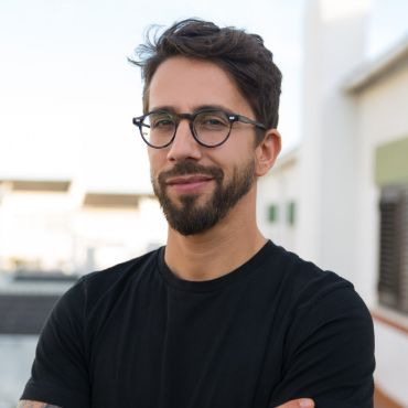 A man wearing glasses and a black t - shirt.