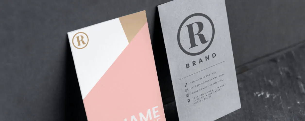 A customized stationery business card with a pink and gold logo.