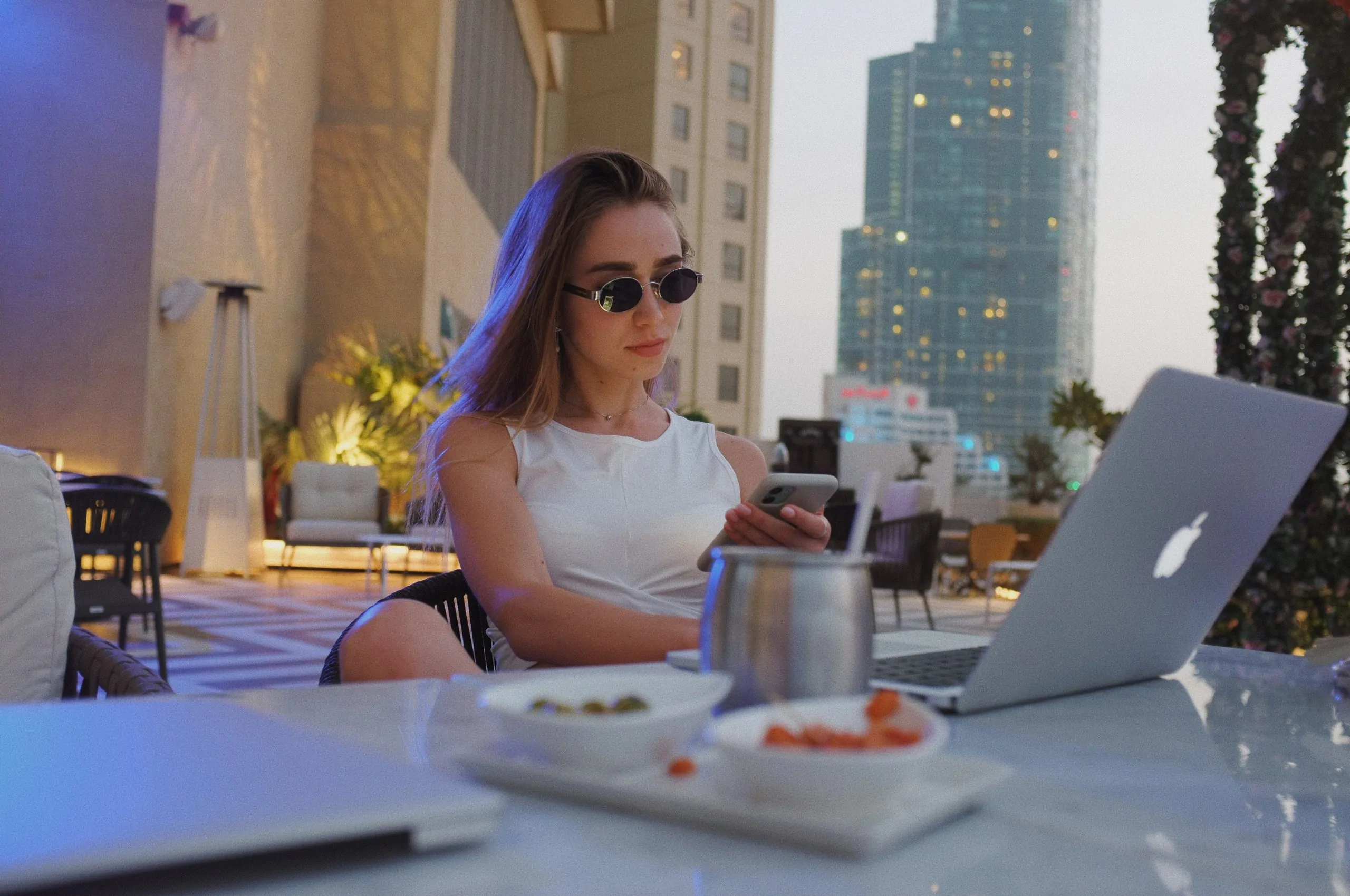 Une femme assise à une table avec un ordinateur portable, rédigeant un e-mail professionnel et une tasse de café.