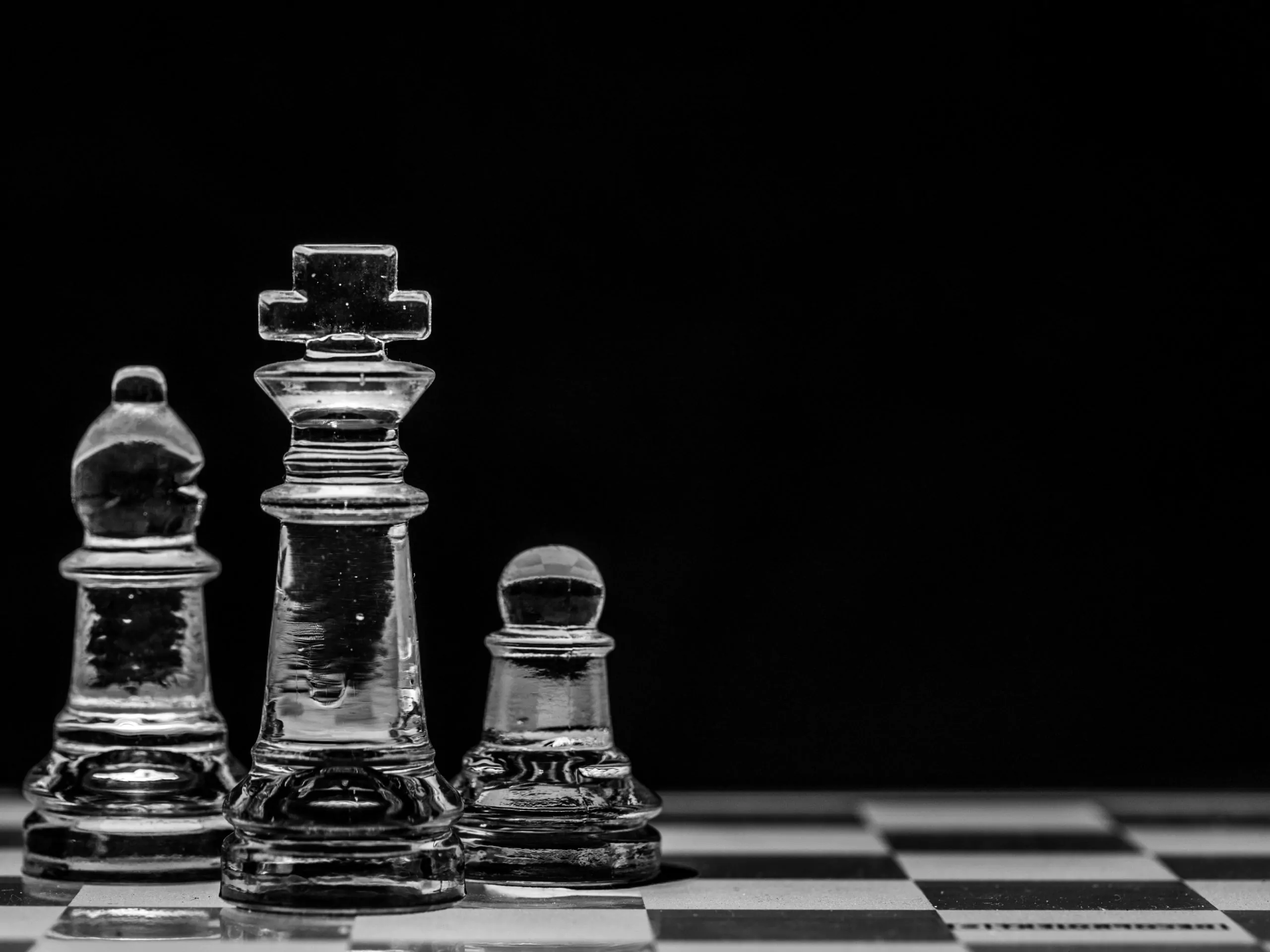 Trois pièces d'échecs sur un échiquier.