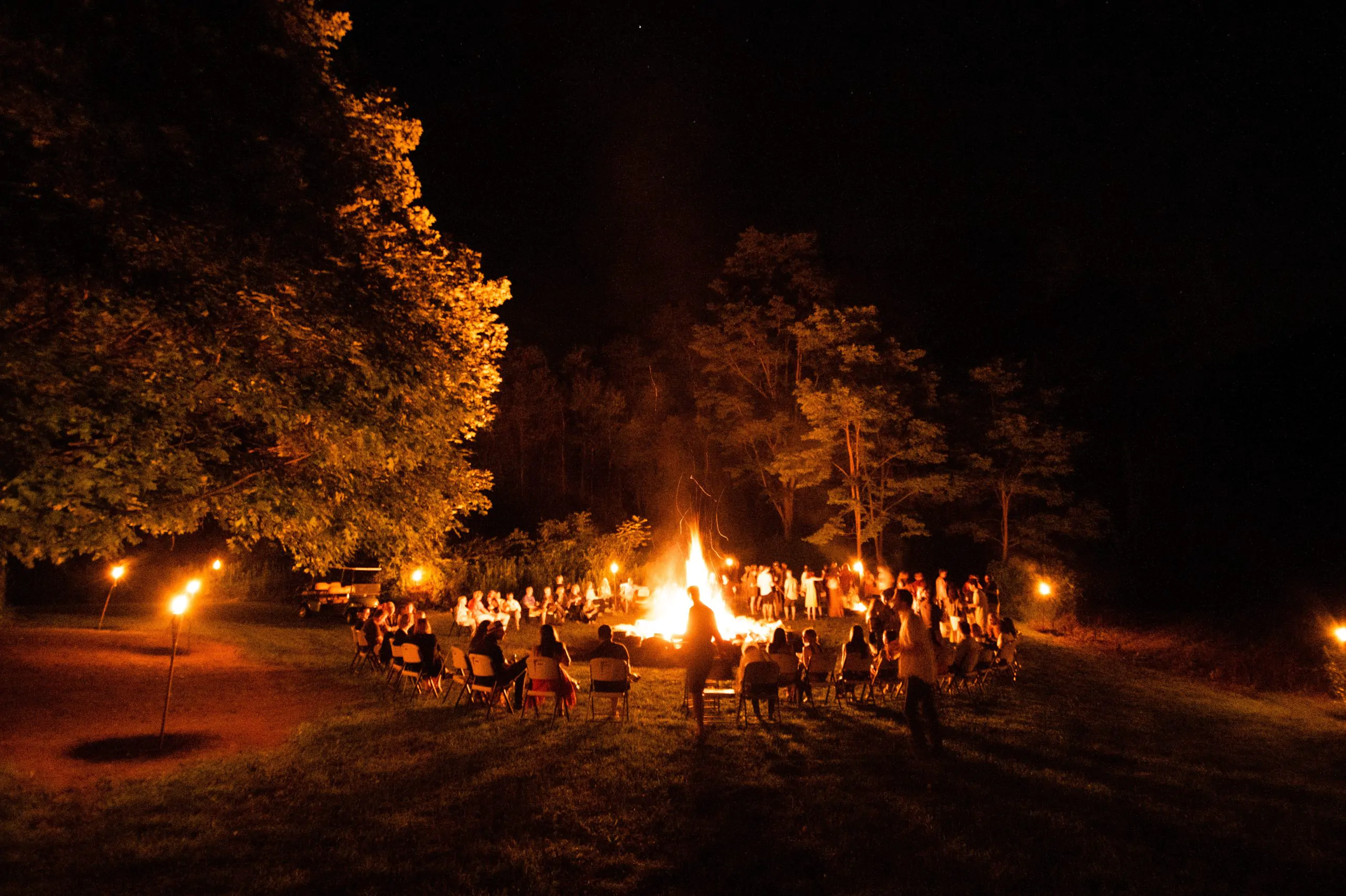 Un groupe de personnes s'est rassemblé autour d'un feu de joie la nuit.