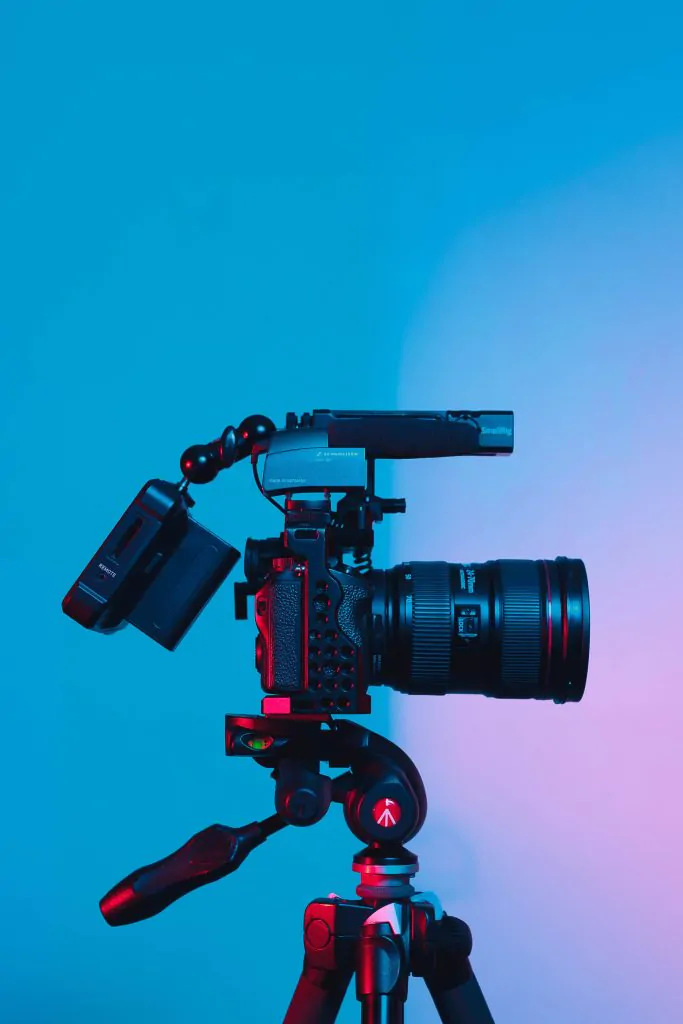 A video camera on a tripod with a blue background showcases the best types of marketing videos.