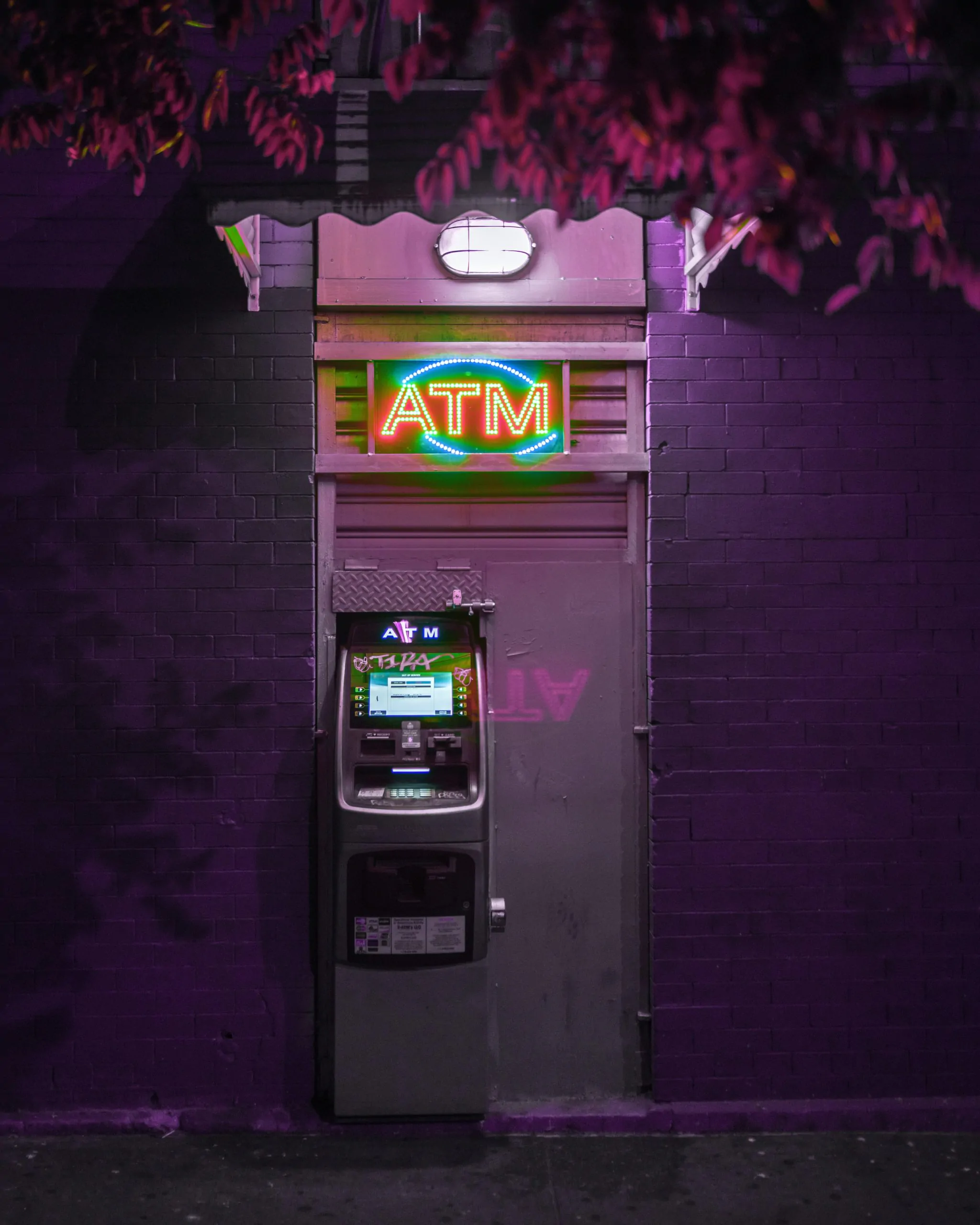 Un distributeur de billets violet avec des publicités Google et le mot "ATM" écrit dessus.