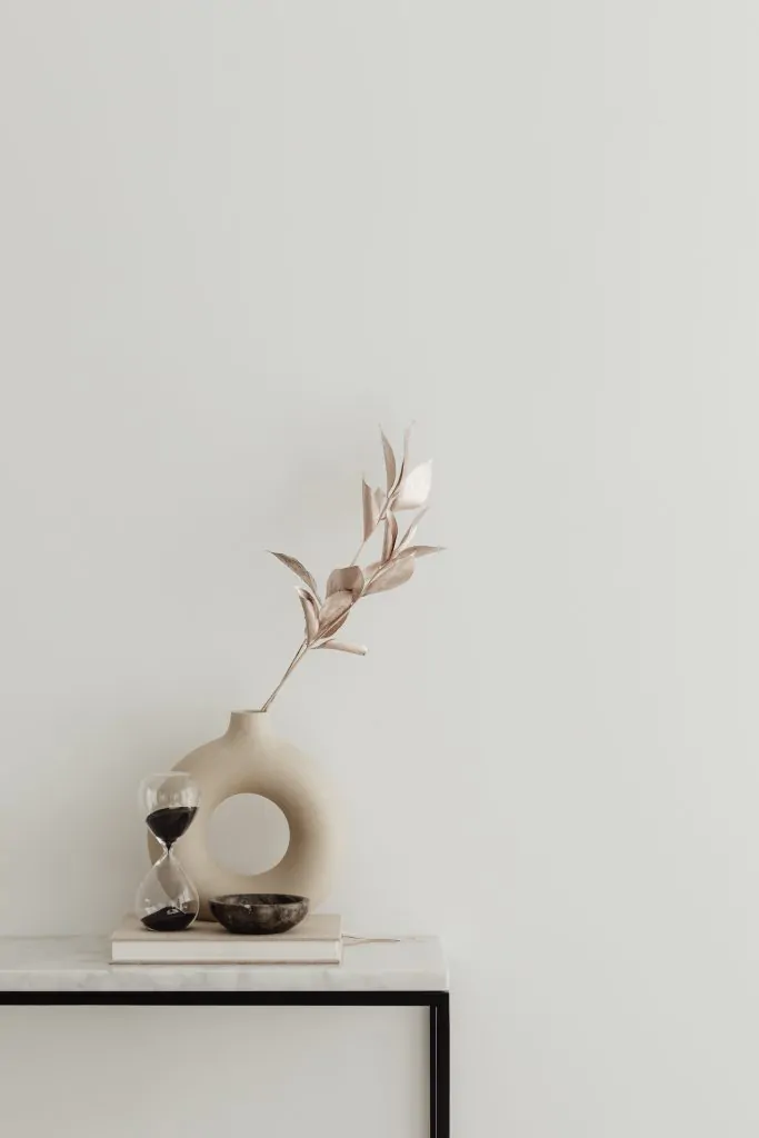 Un vase sur une table ecommerce seo avec une horloge dessus.